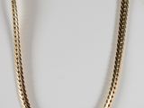 une photo d'un collier en or sur un mannequin