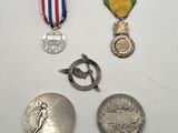 trois médailles et une médaille sur une surface blanche