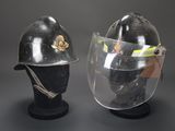 pair of helmets with face shields on display against a gray background