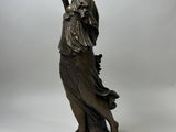an antique bronze statue of a woman holding a bowl