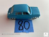une petite voiture bleue posée sur une feuille de papier bleue