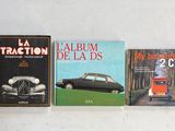 Trois livres sont alignés les uns à côté des autres sur une surface blanche