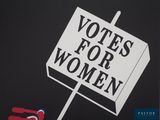 a sign that says votes for women on it