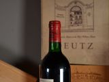 a bottle of wine sitting on a table next to a book