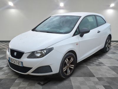 la voiture blanche est garée sur un sol en damier dans le garage