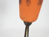 a close up of an orange vase on a table