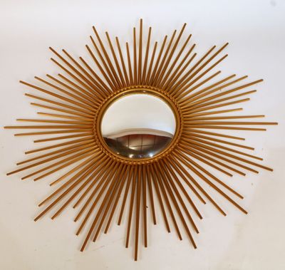 gold sunburst mirror on a white wall with a mirror in the middle