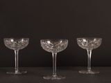 trois verres à vin vides posés sur une table, sur fond noir