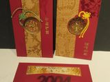 two red and gold chinese new year cards on a white table