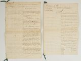 deux vieux papiers sur lesquels il y a des inscriptions, posés sur une table