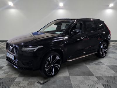 un SUV Volvo noir garé sur un sol à damier dans un showroom