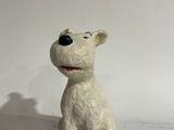 a small white dog figurine sitting on a white surface