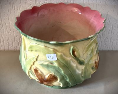 un vase vert et rose posé sur une table
