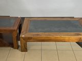 two wooden tables with glass tops on a tiled floor in a room