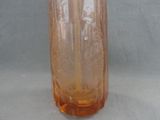 a brown glass vase with a brown lid on a table