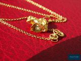 a gold necklace with a heart and a key on a red cloth