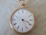 une montre de poche en or avec des chiffres romains sur le cadran
