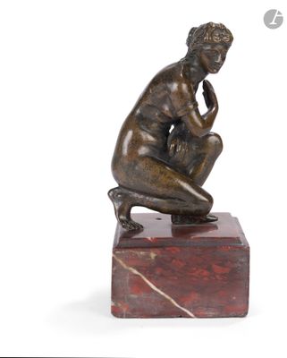 statue d'un homme assis sur un bloc de marbre, la main posée sur le menton