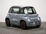 the small car is parked on the checkered floor in the room