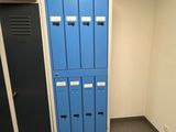 two blue lockers in the corner of a room next to each other