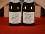 two bottles of wine sitting on a table next to each other