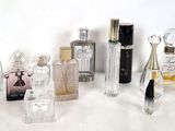 de nombreux flacons de parfum posés sur une table blanche