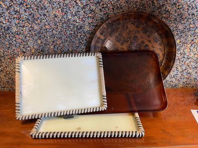 two trays and a plate on a wooden table