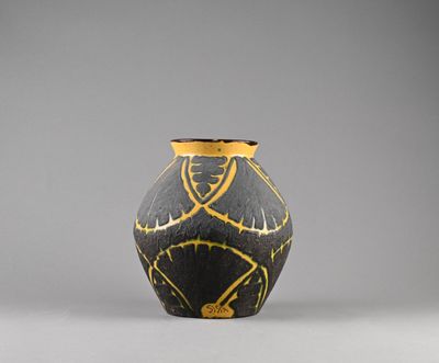 une image représentant un vase noir et doré sur fond gris