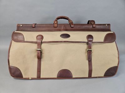 an image of a tan and brown suitcase sitting on top of a table