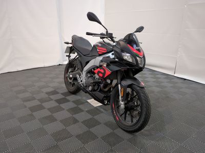 une moto noire et rouge garée dans une pièce