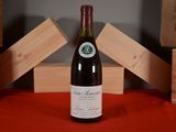a bottle of wine sitting on a red table cloth