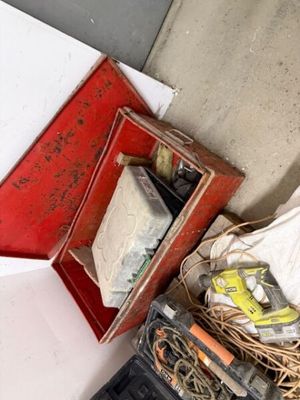 a pile of assorted items on the floor next to a red box
