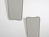 two mirrors on a white wall with a black border