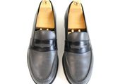 black leather loafers with a gold buckle on the side