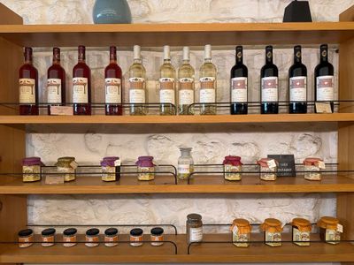 Des bouteilles de vin et des épices sont posées sur une étagère dans un magasin.