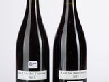 deux bouteilles de vin posées l'une à côté de l'autre sur une surface blanche