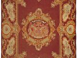 a red and gold rug with a bird on it