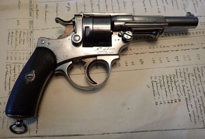 un pistolet posé sur une feuille de papier