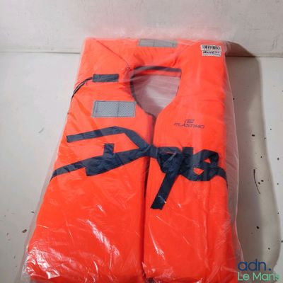 un gilet de sauvetage orange posé sur un sac en plastique