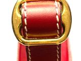 a close up of a red purse with a gold buckle