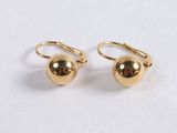 a pair of gold ball earrings on a white surface