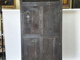 a tall cabinet in the middle of a room with pictures on the wall