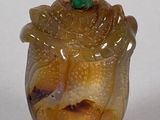 a glass figurine with a green leaf on top of it