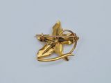a close up of a gold brooch with a flower on it