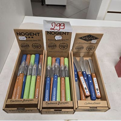 Plusieurs stylos de différentes couleurs se trouvent dans une boîte posée sur un comptoir.