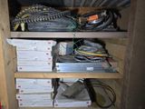 a wooden shelf filled with assorted electronics and wires