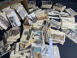 a pile of old photos on a table with a pair of scissors