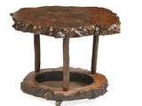 une image représentant une table en bois montée sur roulettes, dont le plateau est constitué d'une souche d'arbre