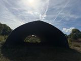 a large metal structure sitting in the middle of a field