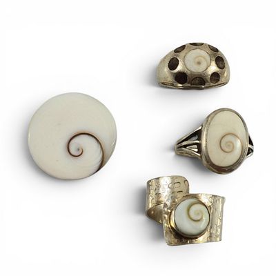 trois bijoux argentés et blancs posés sur un fond blanc